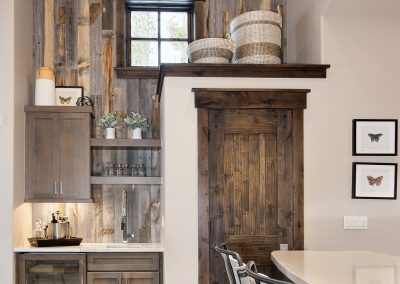 Wood paneling walls and butterfly artwork make this mountain modern wet bar gorgeous